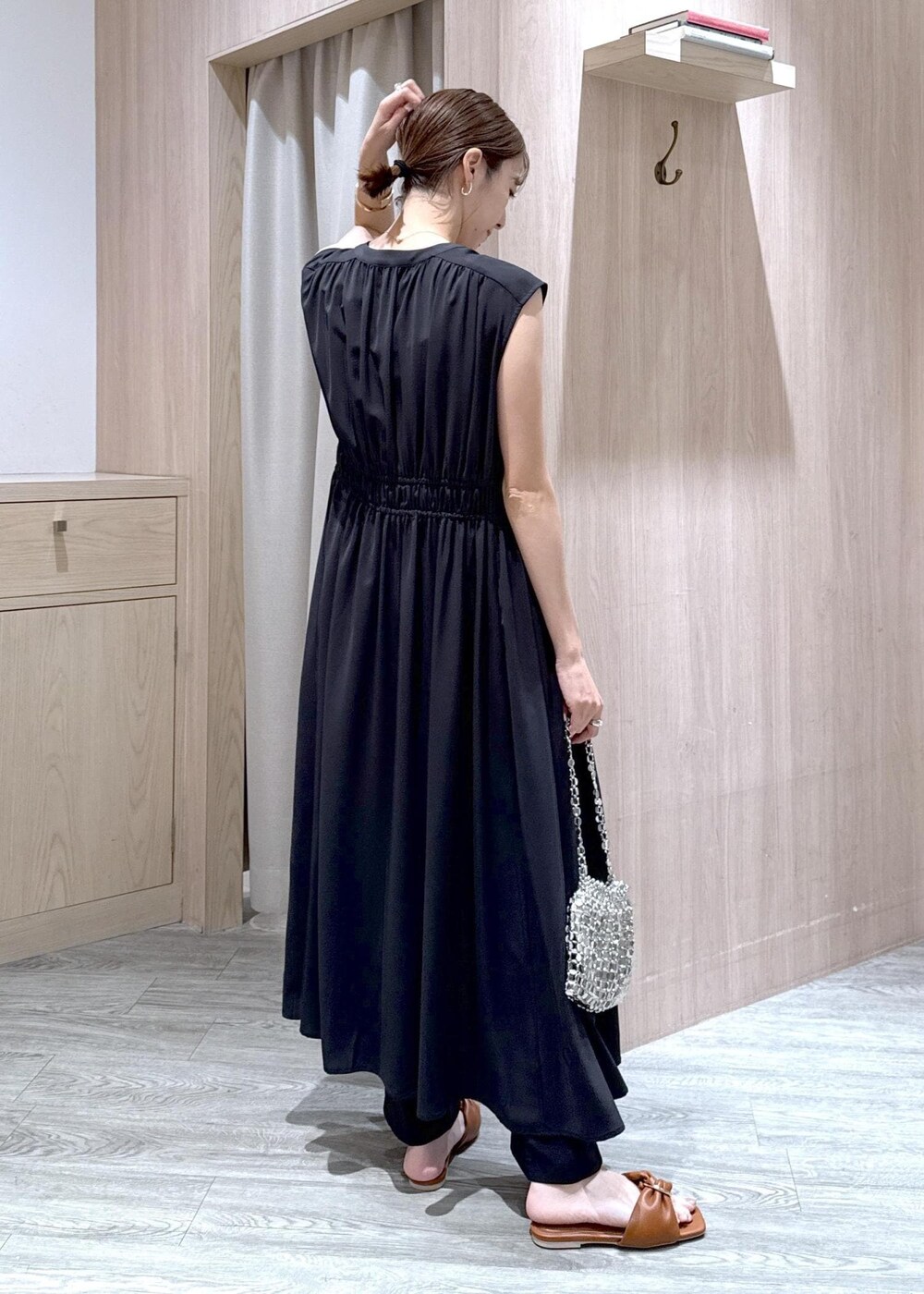 ホワイト系のタンクトップ、ブラック系のスラックス、シルバー系のハンドバッグを着用したレディースの春コーディネートの3枚目の写真