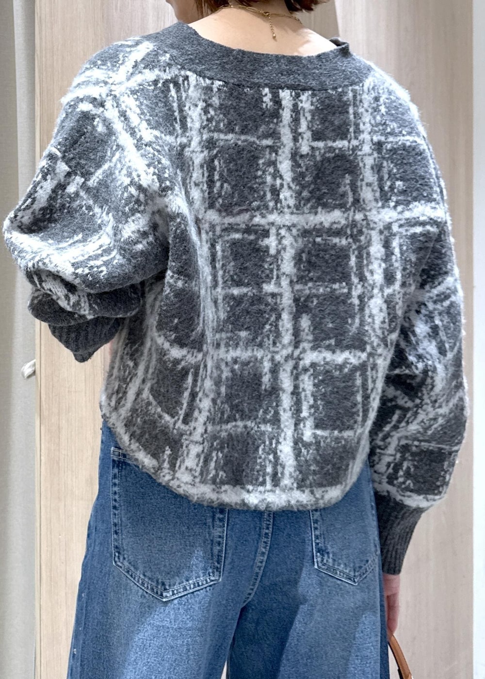 ブルー系のデニムパンツ、イエロー系のハンドバッグ、グレー系のカーディガン/ボレロを着用したレディースの冬コーディネートの7枚目の写真