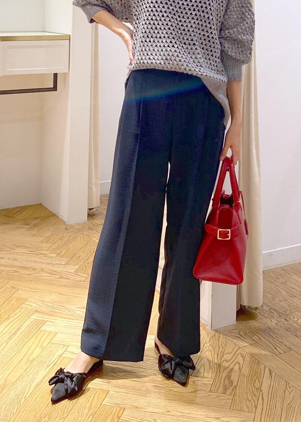 ブルー系のスラックス、ブラック系のサンダル、グレー系のニット/セーターを着用したレディースの秋コーディネートの5枚目の写真