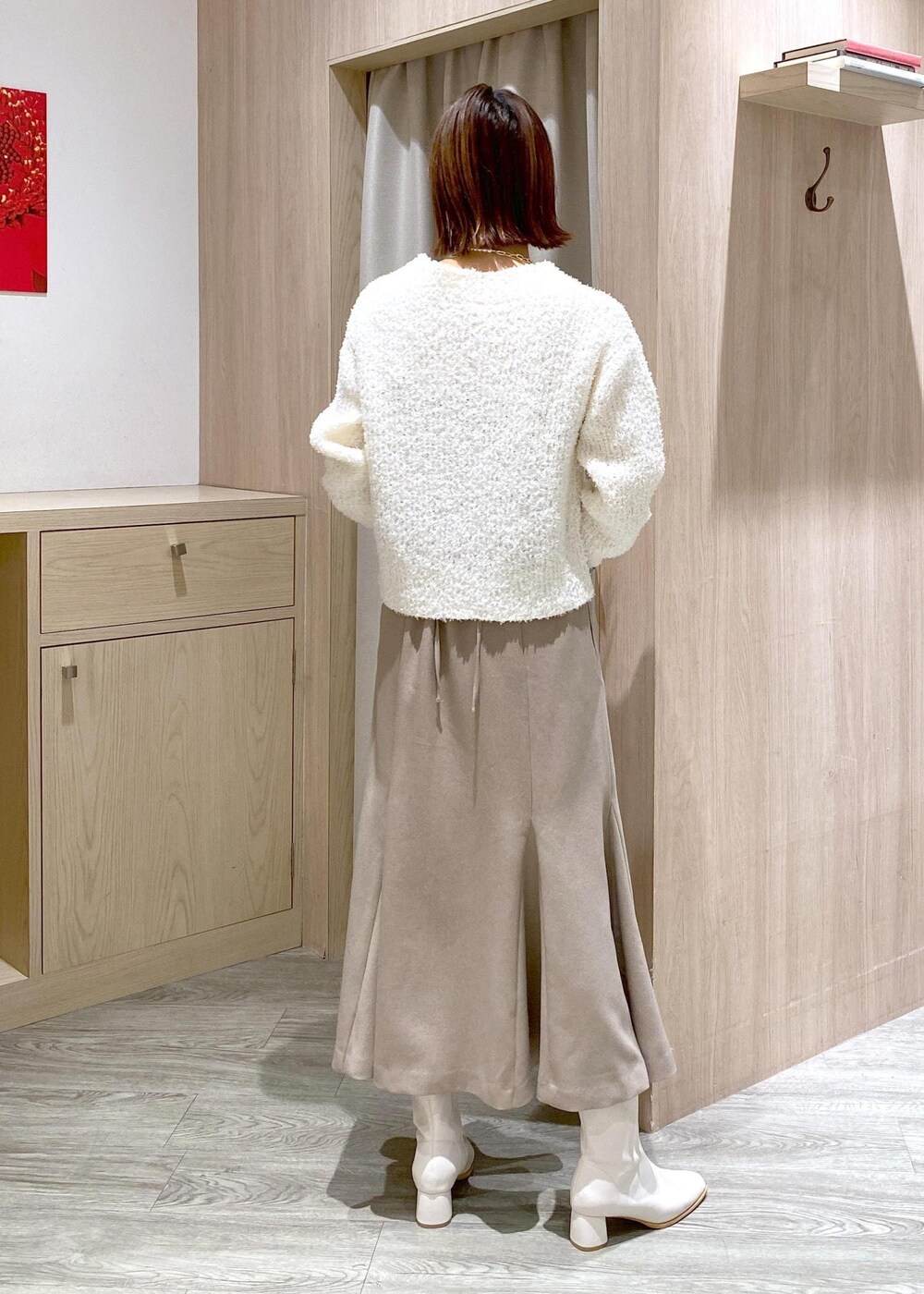 ホワイト系のブーツ、ベージュ系のスカート、ホワイト系のカーディガン/ボレロを着用したレディースの冬コーディネートの3枚目の写真