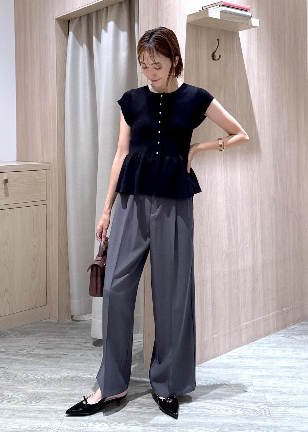 ブラウン系のショルダーバッグ、ベージュ系のキャミソール、ブラック系のパンプスを着用したレディースの夏コーディネートの2枚目の写真