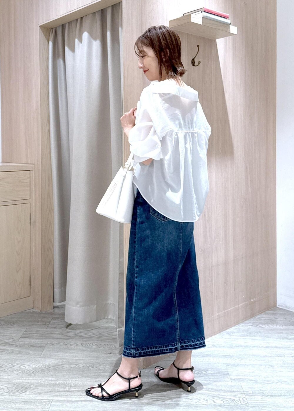 ブルー系のデニムスカート、ベージュ系のキャミソール、ブラック系のサンダルを着用したレディースの夏コーディネートの3枚目の写真