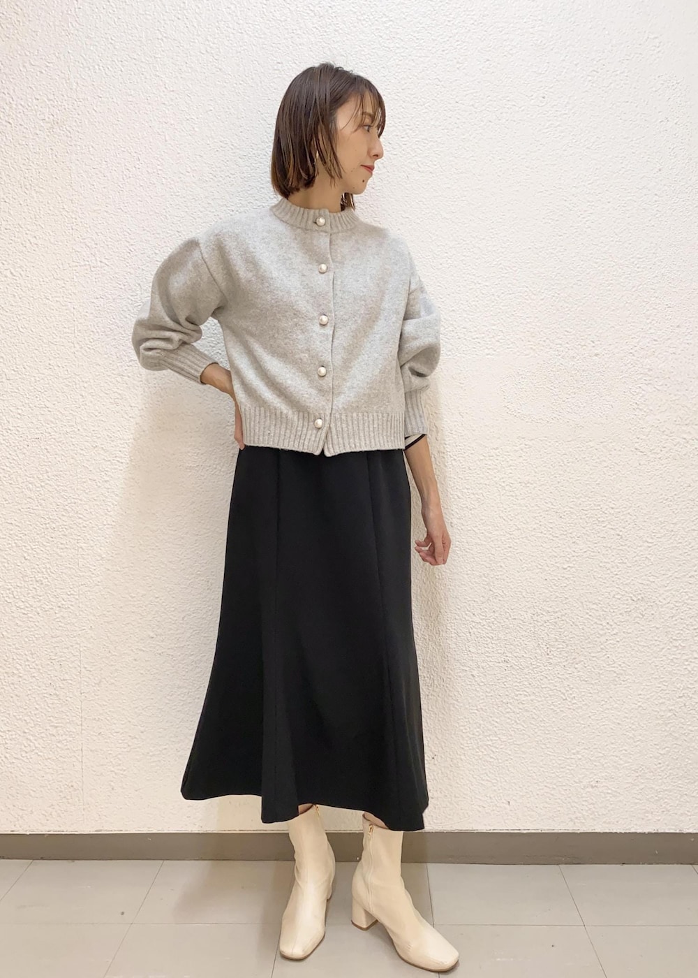 グレー系のカーディガン/ボレロ、ベージュ系のトートバッグ、ホワイト系のその他アウターを着用したレディースの冬コーディネートの5枚目の写真