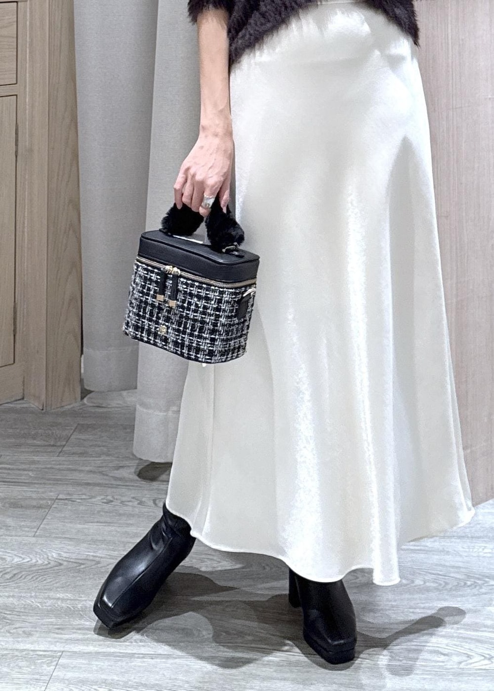 ブラック系のブーツ、ホワイト系のスカート、グレー系のカーディガン/ボレロを着用したレディースの冬コーディネートの5枚目の写真