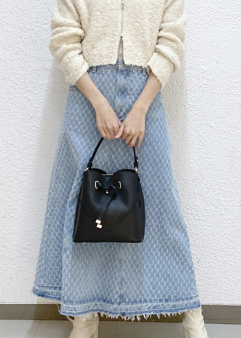 ホワイト系のTシャツ/カットソー、ブルー系のデニムスカート、ホワイト系のカーディガン/ボレロを着用したレディースの冬コーディネートの3枚目の写真