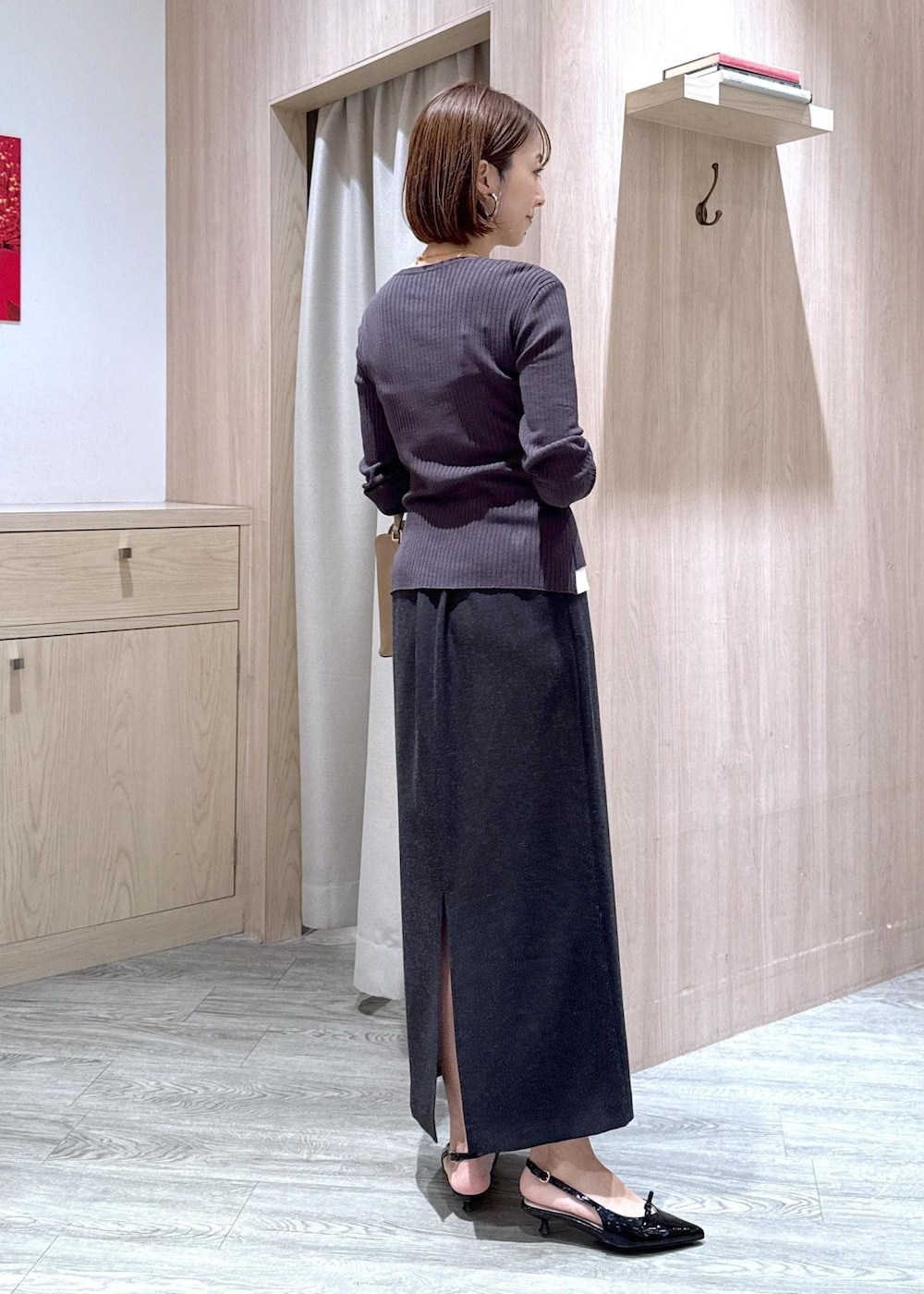 ブラック系のキャミソール、ブラック系のパンプス、グレー系のスカートを着用したレディースの秋コーディネートの4枚目の写真