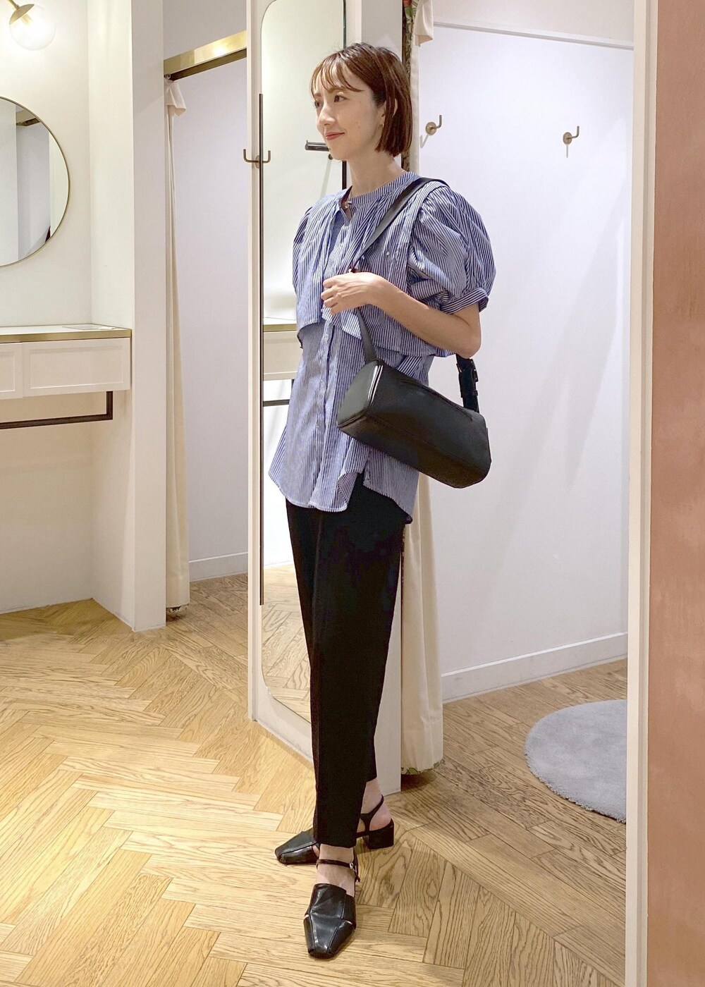 ブラック系のキャミソール、ブラック系のショルダーバッグ、ブラック系のサンダルを着用したレディースの夏コーディネートの3枚目の写真