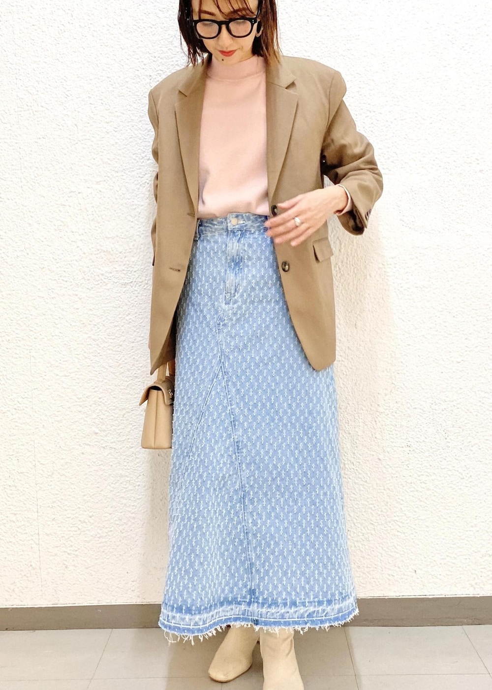 ベージュ系のショルダーバッグ、ピンク系のニット/セーター、ベージュ系のテーラードジャケットを着用したレディースの冬コーディネートの3枚目の写真