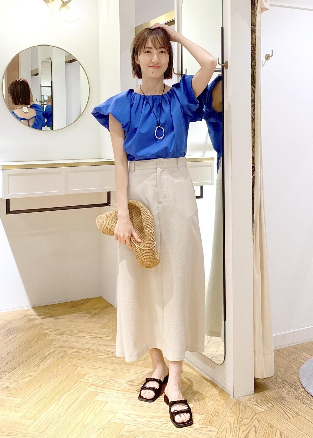 ブラック系のキャミソール、ブラック系のサンダル、ホワイト系のスカートを着用したレディースの春コーディネートの6枚目の写真