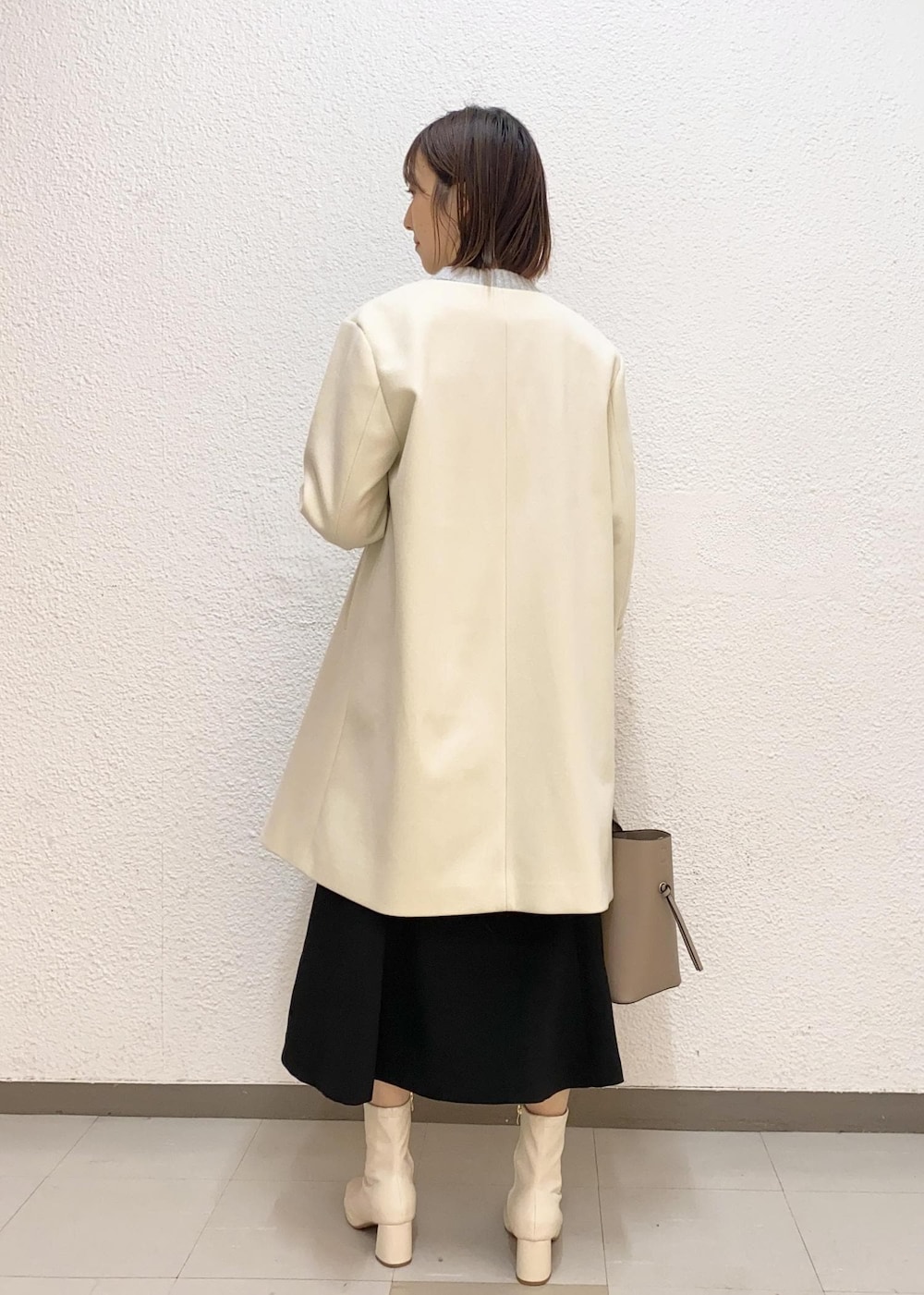 グレー系のカーディガン/ボレロ、ベージュ系のトートバッグ、ホワイト系のその他アウターを着用したレディースの冬コーディネートの2枚目の写真