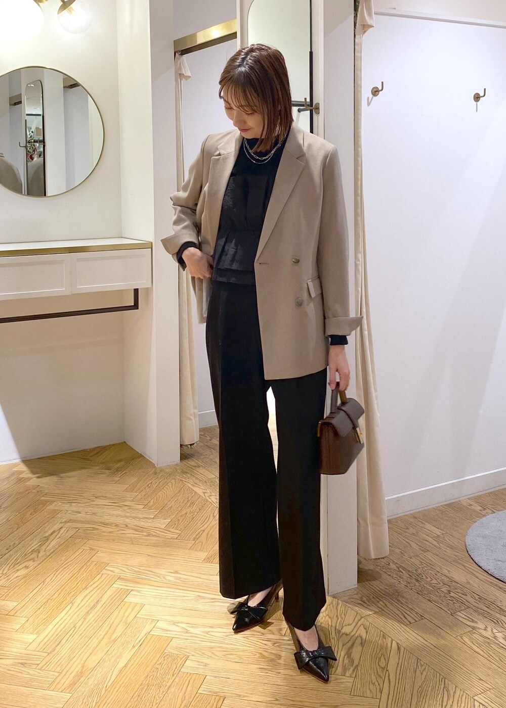ブラック系のパンプス、ブラック系のニット/セーター、ブラック系のスラックスを着用したレディースの冬コーディネートの2枚目の写真