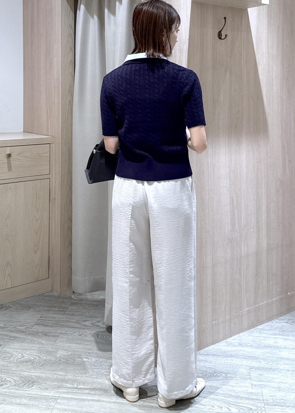 ホワイト系のその他パンツ、ホワイト系のパンプス、ブラック系のショルダーバッグを着用したレディースの春コーディネートの2枚目の写真