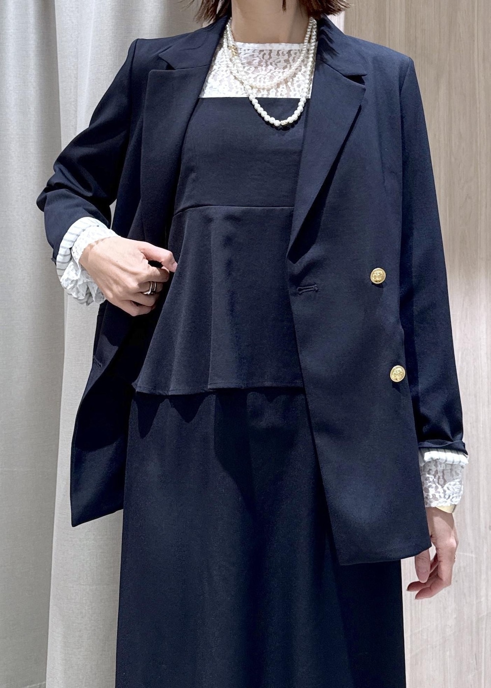 ブラック系のパンプス、ブルー系のテーラードジャケット、ブルー系のワンピースを着用したレディースの冬コーディネートの6枚目の写真