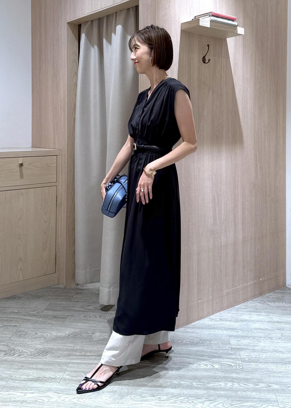 ブラック系のサンダル、ホワイト系のスラックス、ブラック系のワンピースを着用したレディースの夏コーディネートの2枚目の写真