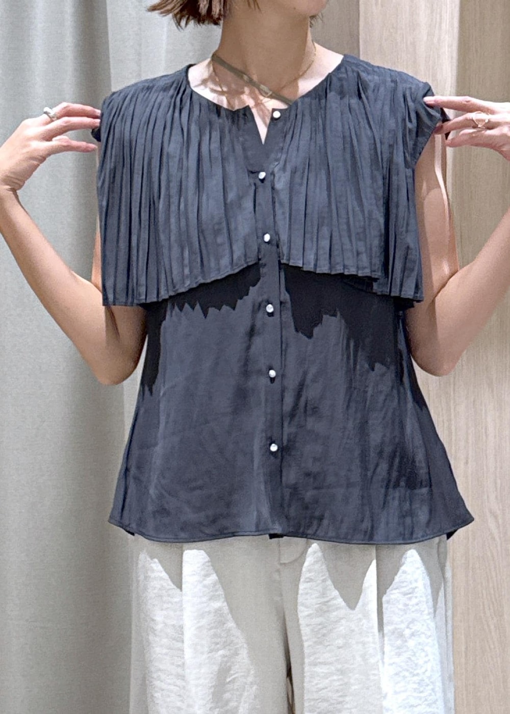 ブラック系のハンドバッグ、ブラック系のパンプス、ホワイト系のスラックスを着用したレディースの夏コーディネートの9枚目の写真