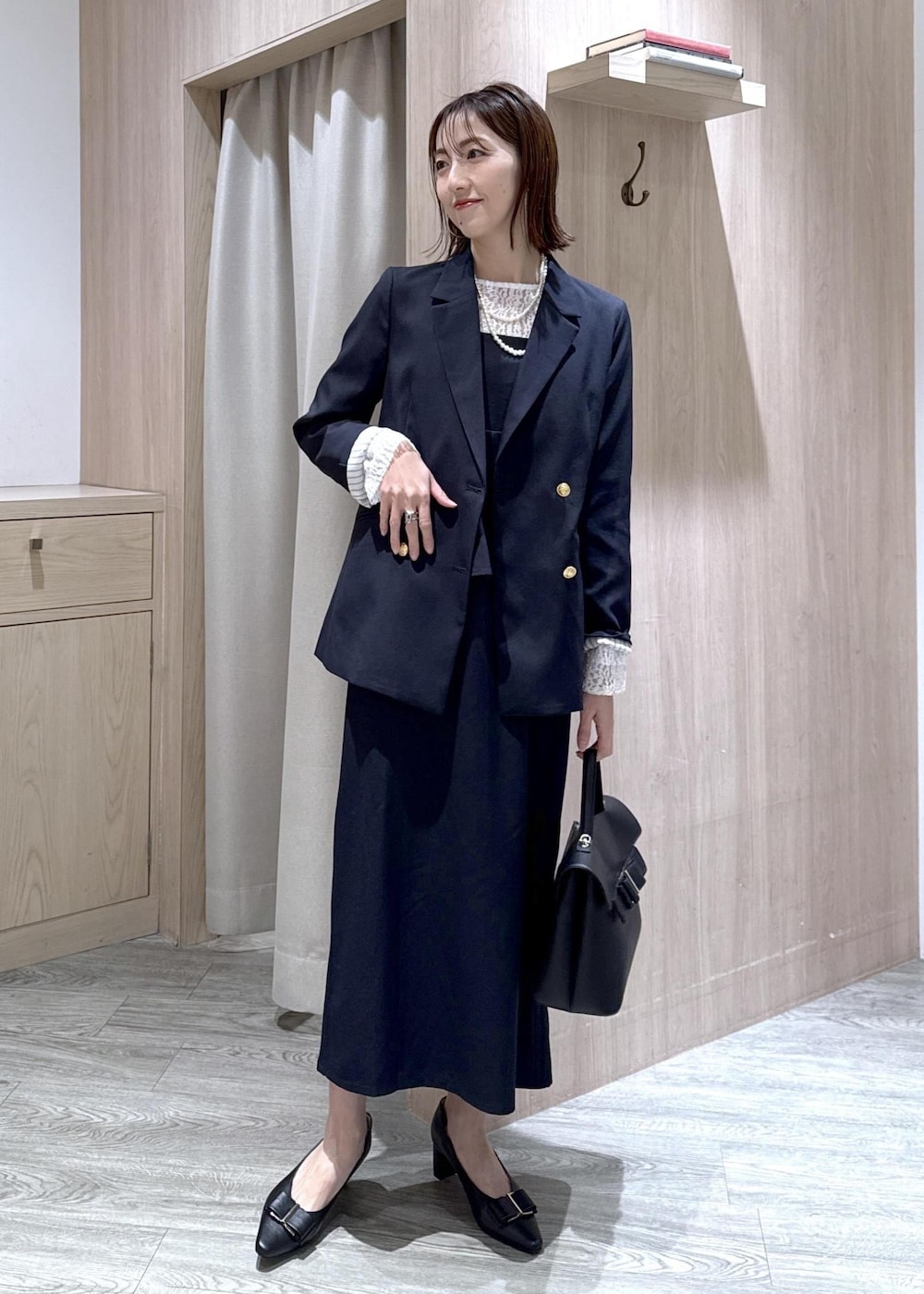 ブラック系のパンプス、ブルー系のテーラードジャケット、ブルー系のワンピースを着用したレディースの冬コーディネートの3枚目の写真