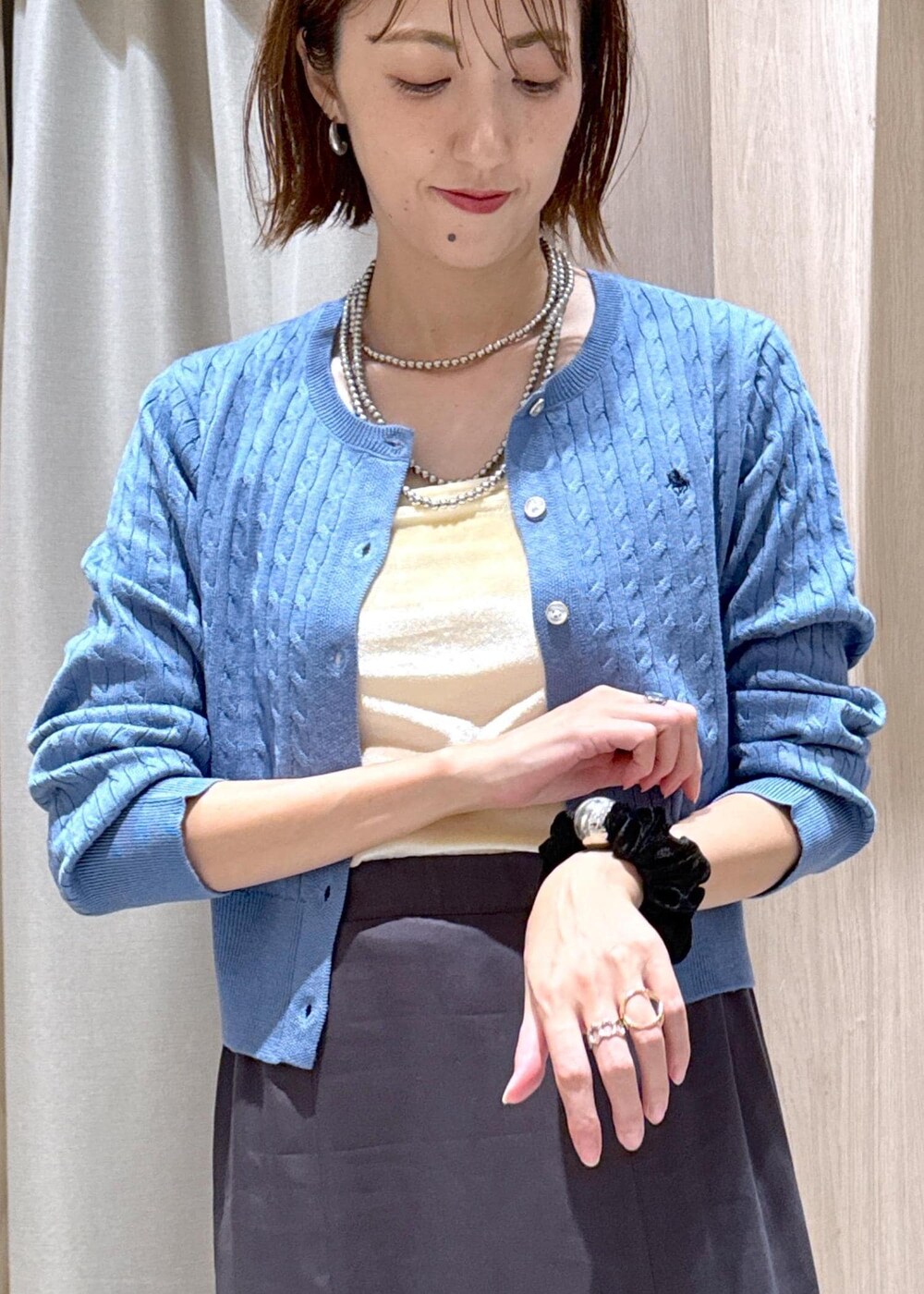 ブラック系のショルダーバッグ、グレー系のスカート、ブルー系のカーディガン/ボレロを着用したレディースの秋コーディネートの8枚目の写真