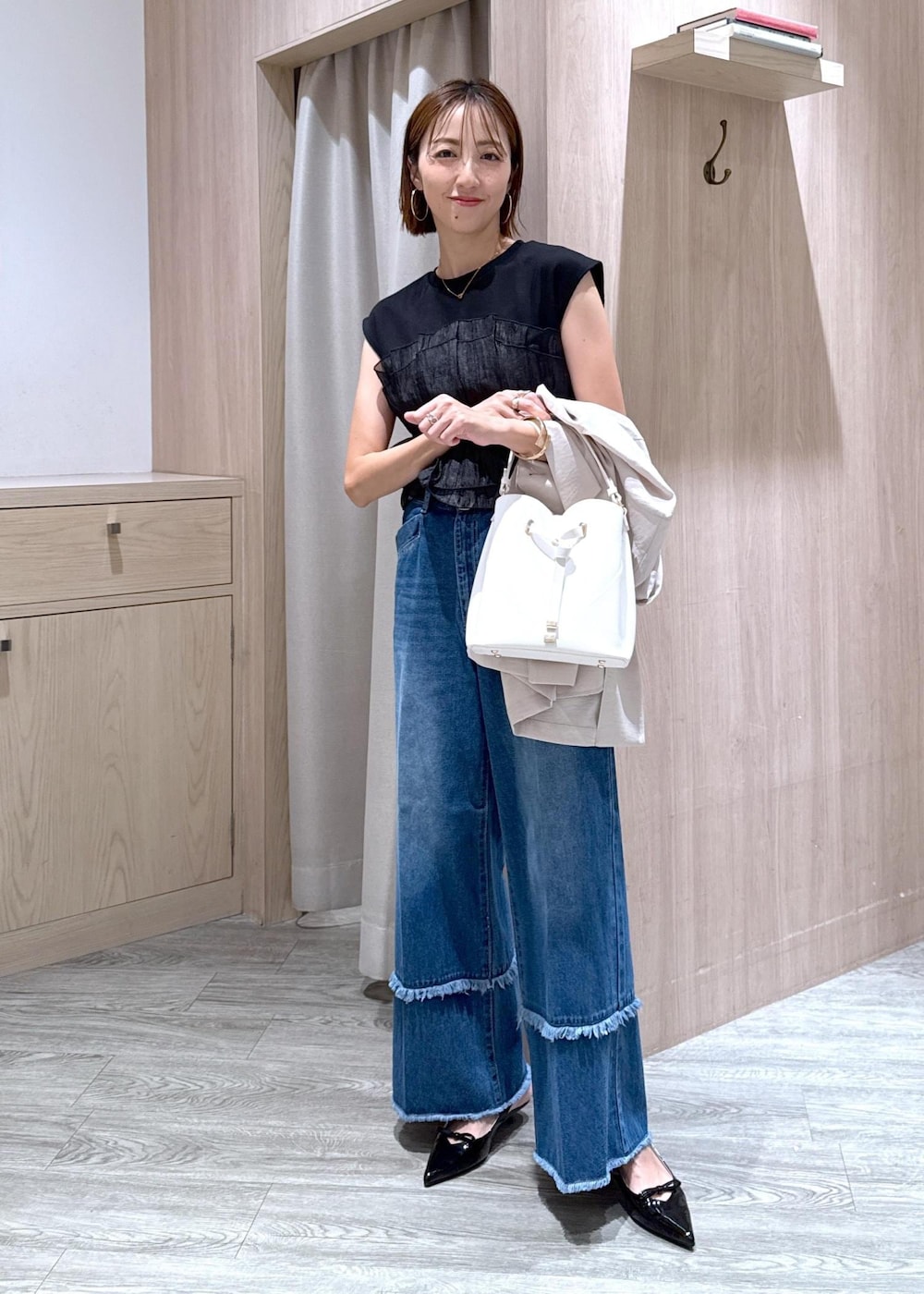 ホワイト系のショルダーバッグ、ブラック系のパンプス、ブラック系のTシャツ/カットソーを着用したレディースの夏コーディネートの2枚目の写真