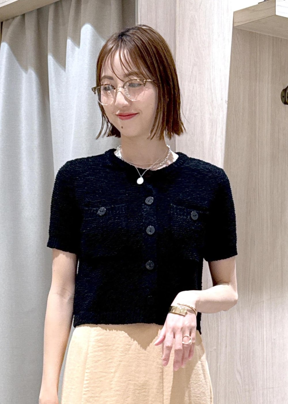 ブラック系のパンプス、オレンジ系のスカート、ブラック系のハンドバッグを着用したレディースの春コーディネートの8枚目の写真