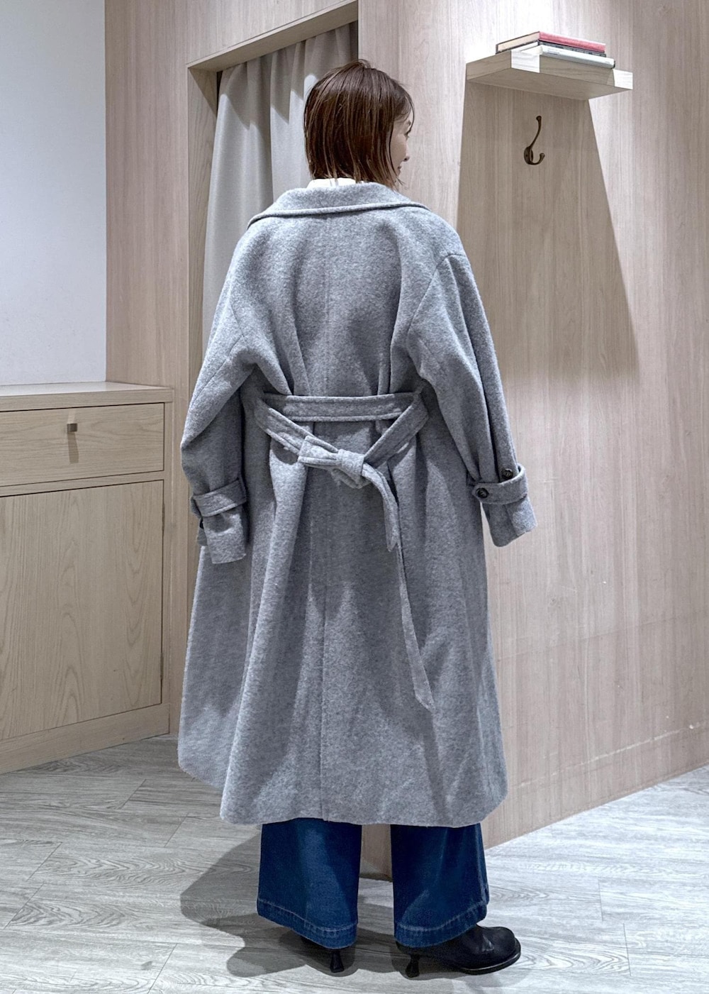 グレー系のその他アウター、ブラウン系のニット/セーター、ブルー系のデニムパンツを着用したレディースの冬コーディネートの2枚目の写真