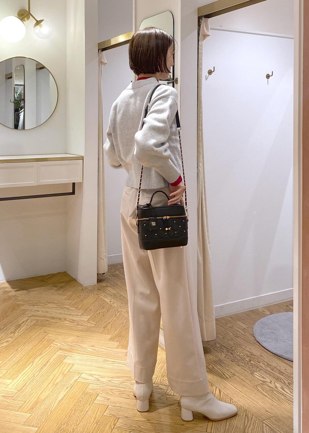 ホワイト系のブーツ、グレー系のカーディガン/ボレロ、レッド系のニット/セーターを着用したレディースの冬コーディネートの4枚目の写真