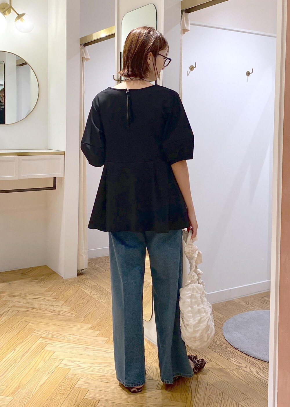 その他のサンダル、ブラック系のTシャツ/カットソー、ブルー系のデニムパンツを着用したレディースの秋コーディネートの4枚目の写真