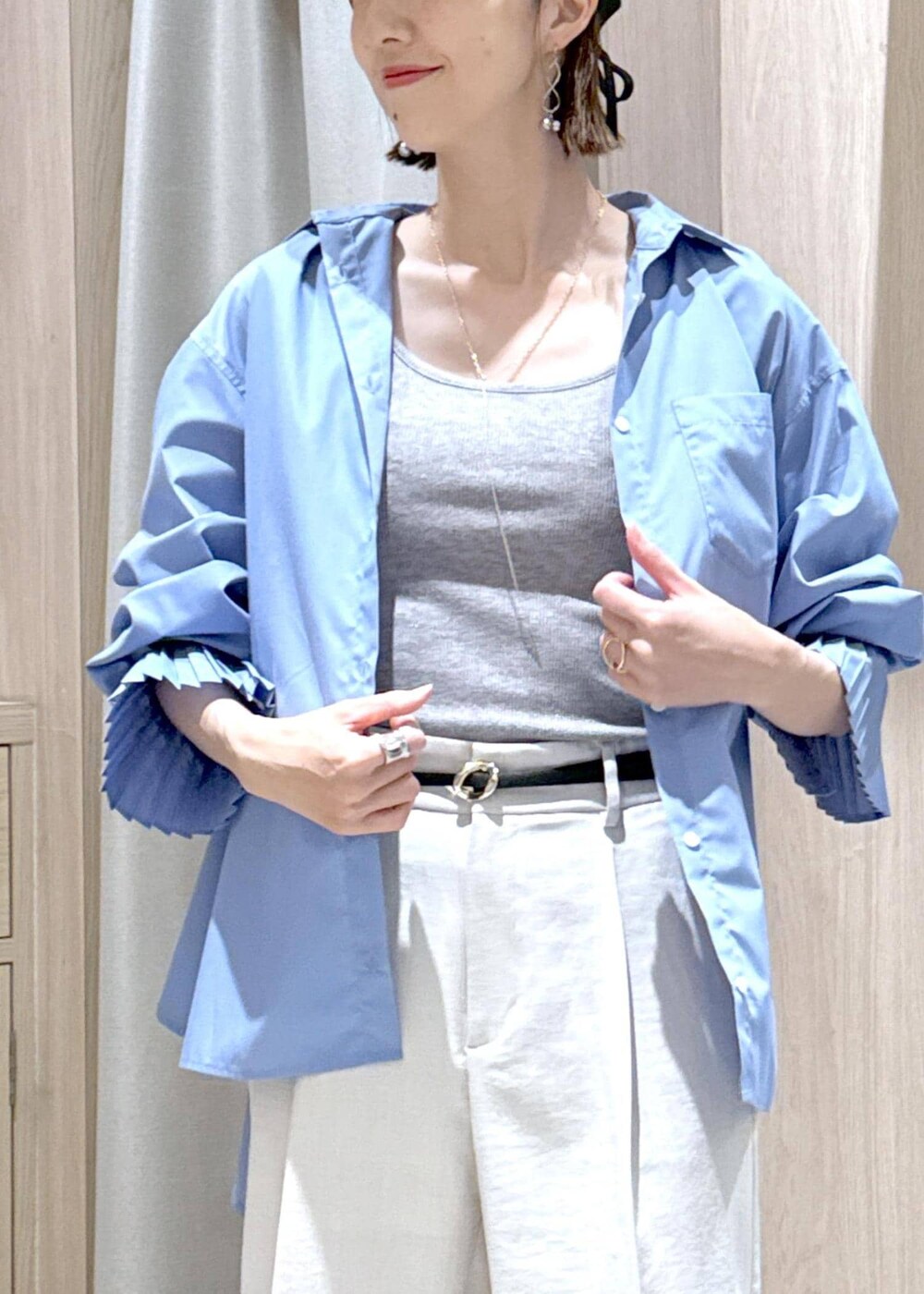 グレー系のタンクトップ、ブルー系のシャツ/ブラウス、ブラック系のショルダーバッグを着用したレディースの春コーディネートの9枚目の写真