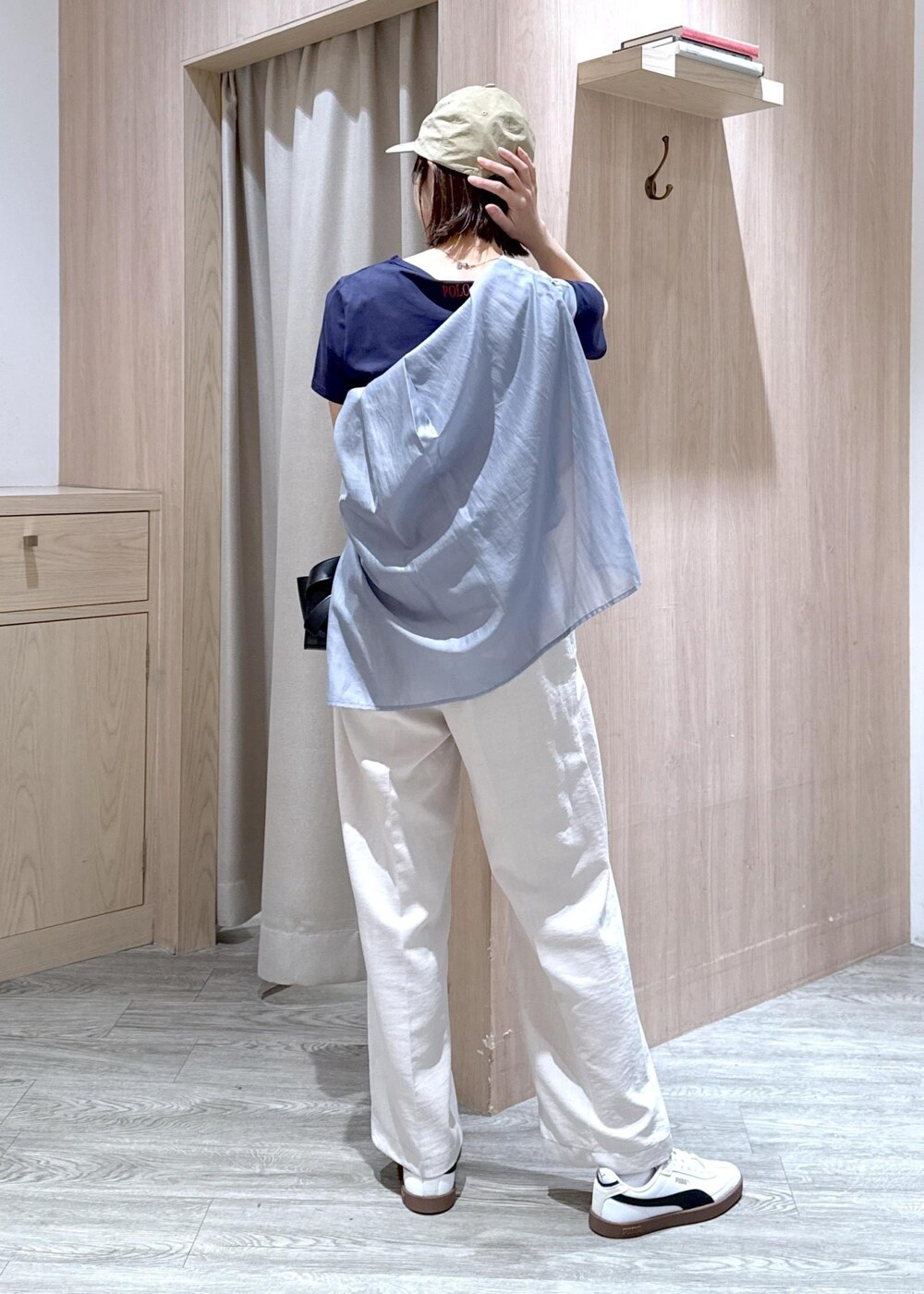 ブラック系のショルダーバッグ、グレー系のシャツ/ブラウス、ホワイト系のスラックスを着用したレディースの春コーディネートの3枚目の写真