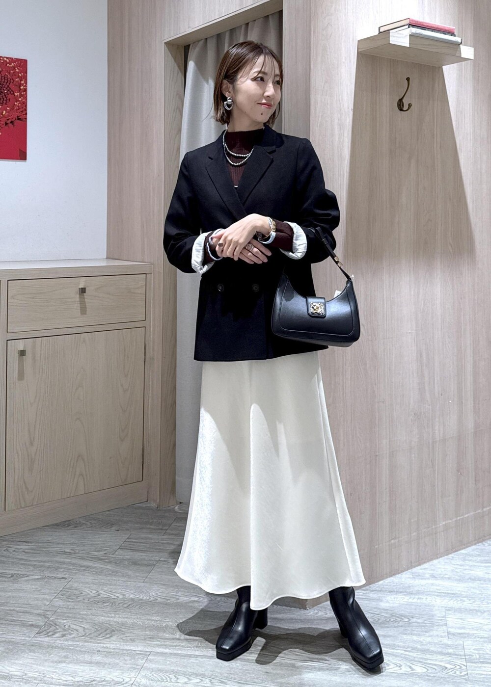 ブラック系のショルダーバッグ、ブラック系のテーラードジャケット、ブラック系のブーツを着用したレディースの冬コーディネートの10枚目の写真