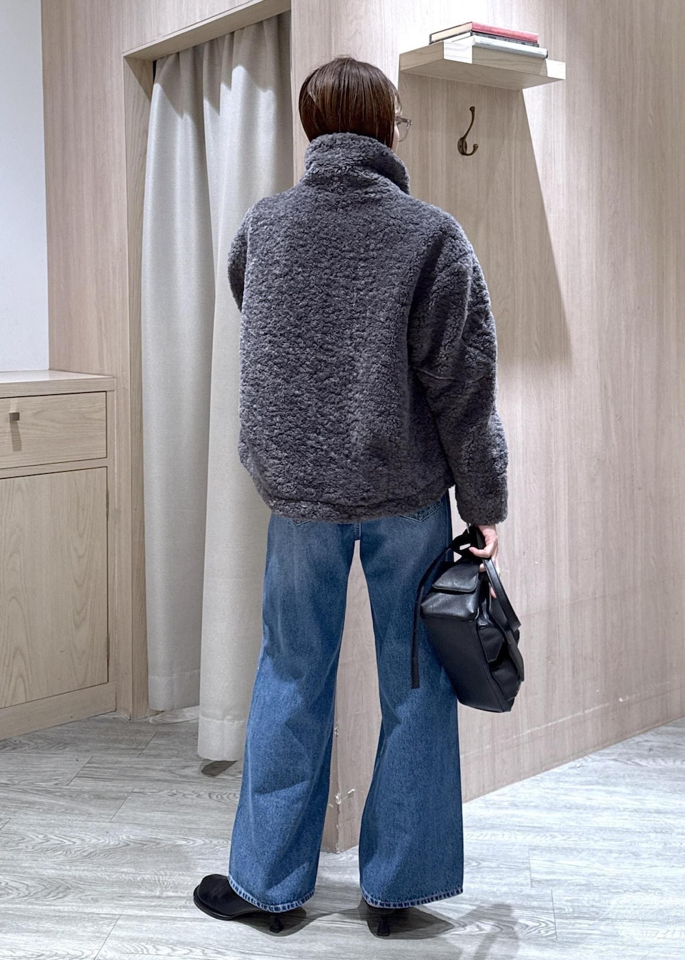 グレー系のブルゾン、グレー系のニット/セーター、ブルー系のデニムパンツを着用したレディースの冬コーディネートの3枚目の写真