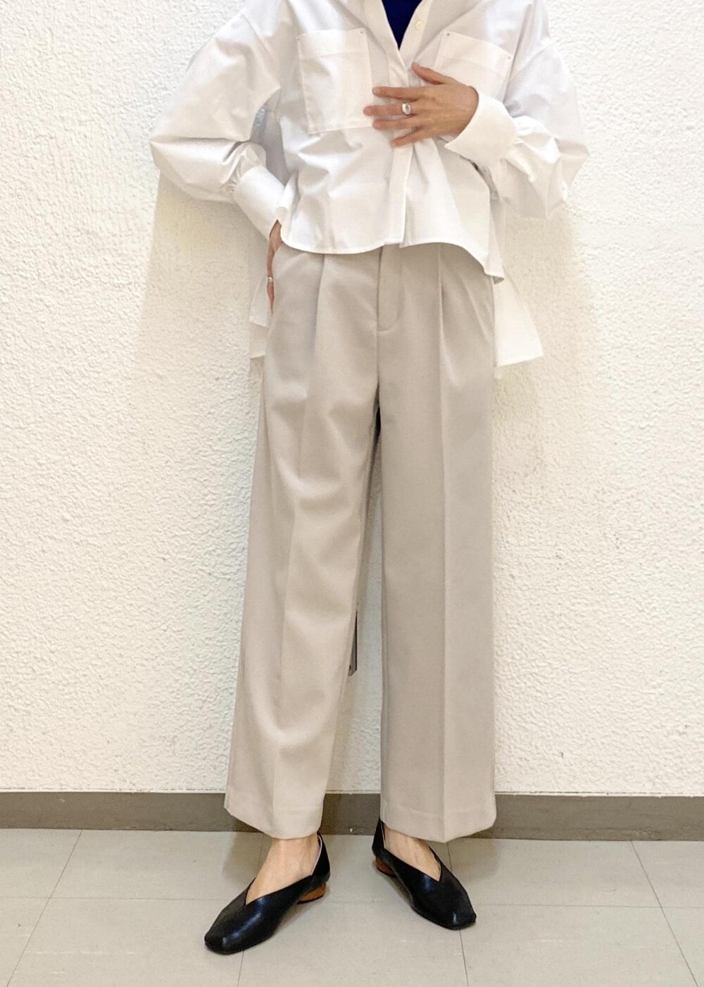 ブルー系のニット/セーター、グレー系のスラックス、ブラック系のハンドバッグを着用したレディースの冬コーディネートの4枚目の写真