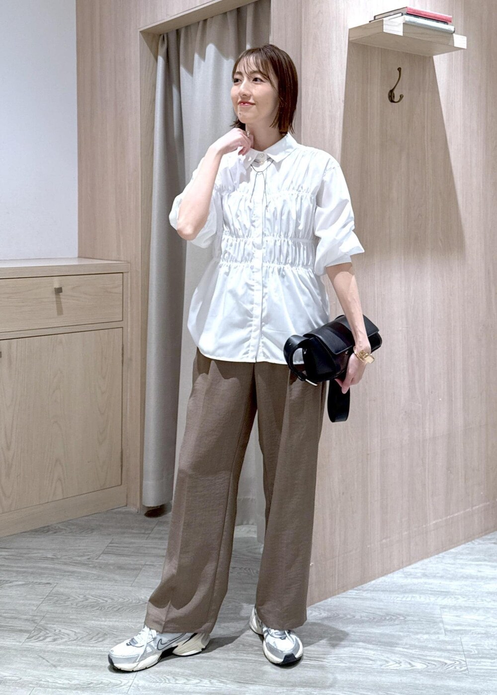 ホワイト系のシャツ/ブラウス、ブラック系のショルダーバッグ、グリーン系のスラックスを着用したレディースの春コーディネートの9枚目の写真