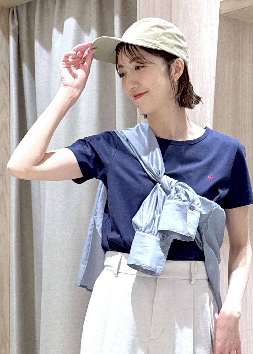 ブラック系のショルダーバッグ、グレー系のシャツ/ブラウス、ホワイト系のスラックスを着用したレディースの春コーディネートの7枚目の写真