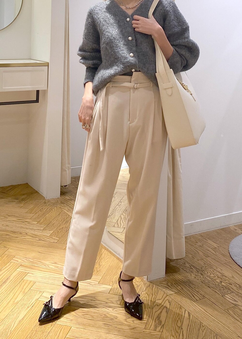 ホワイト系のトートバッグ、ブラック系のパンプス、ベージュ系のその他パンツを着用したレディースの冬コーディネートの6枚目の写真