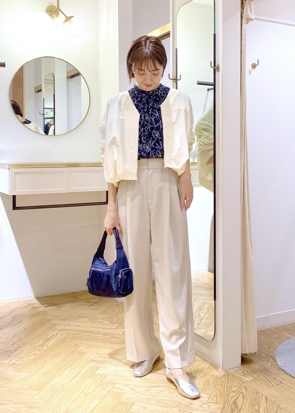 ブルー系のハンドバッグ、シルバー系のパンプス、ブルー系のシャツ/ブラウスを着用したレディースの春コーディネートの6枚目の写真