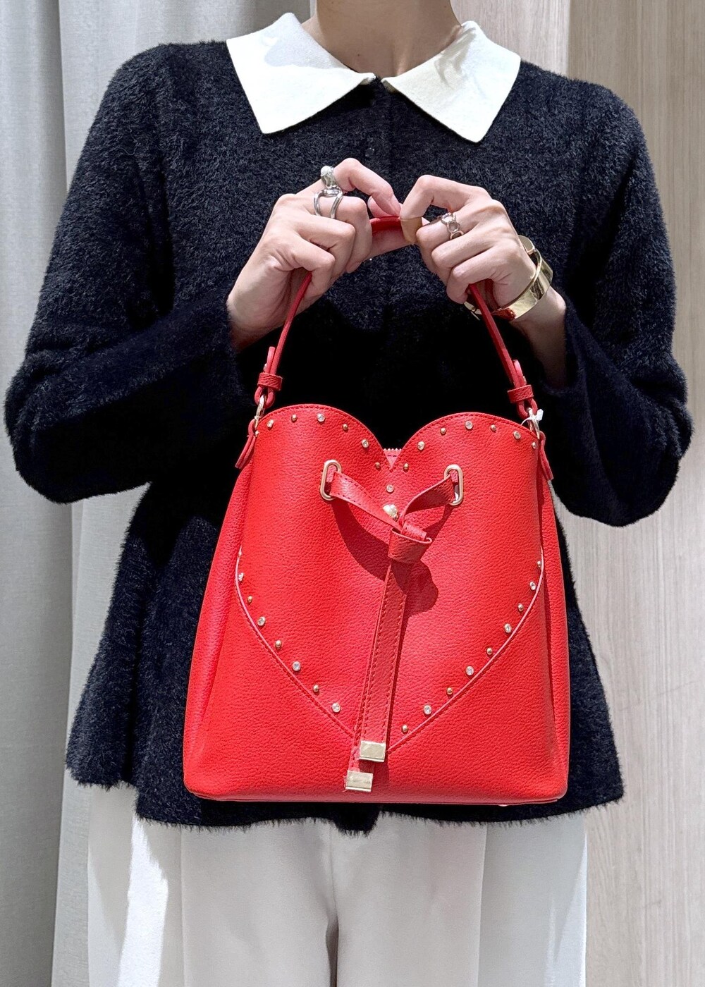 ブラック系のダウンジャケット/コート、ホワイト系のスラックス、ブラック系のニット/セーターを着用したレディースの冬コーディネートの8枚目の写真