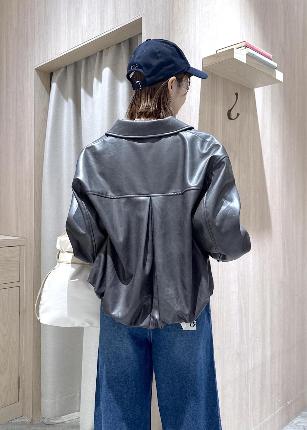 ホワイト系のトートバッグ、ブラック系のブルゾン、ホワイト系のTシャツ/カットソーを着用したレディースの冬コーディネートの8枚目の写真