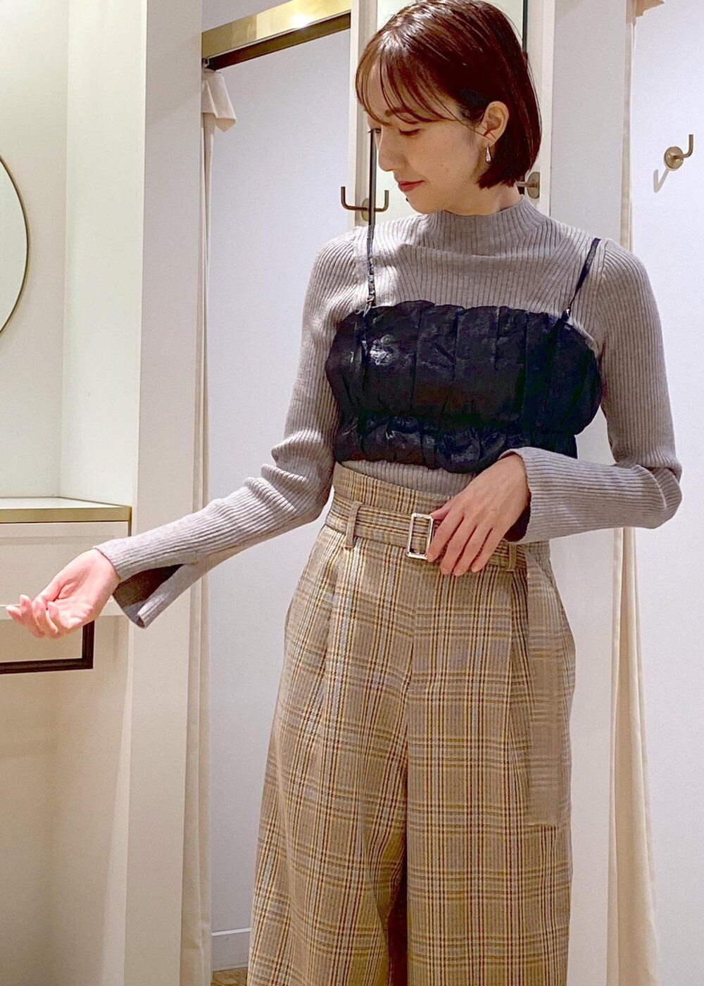 ブラック系のショルダーバッグ、ブラック系のブーツ、ベージュ系のスラックスを着用したレディースの秋コーディネートの8枚目の写真