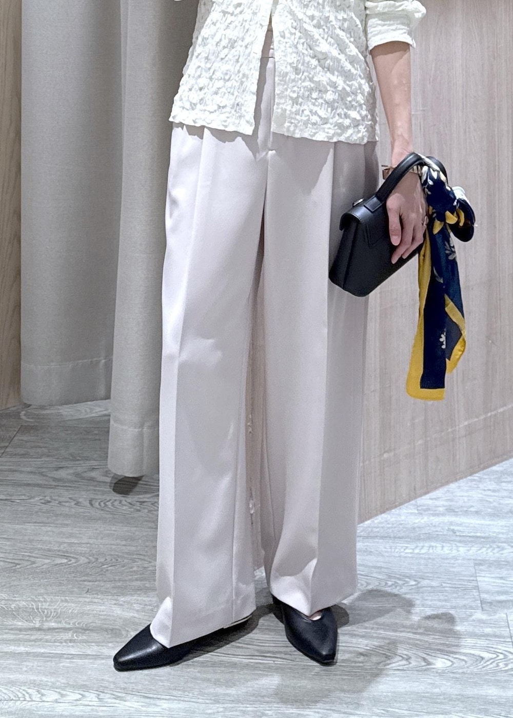 ベージュ系のその他パンツ、ホワイト系のカーディガン/ボレロ、ブラック系のショルダーバッグを着用したレディースの春コーディネートの4枚目の写真