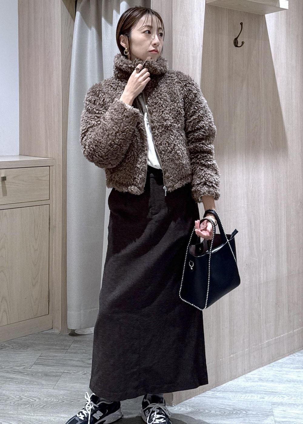 ブラウン系のスカート、ブラウン系のブルゾン、ホワイト系のスウェットを着用したレディースの秋コーディネートの2枚目の写真