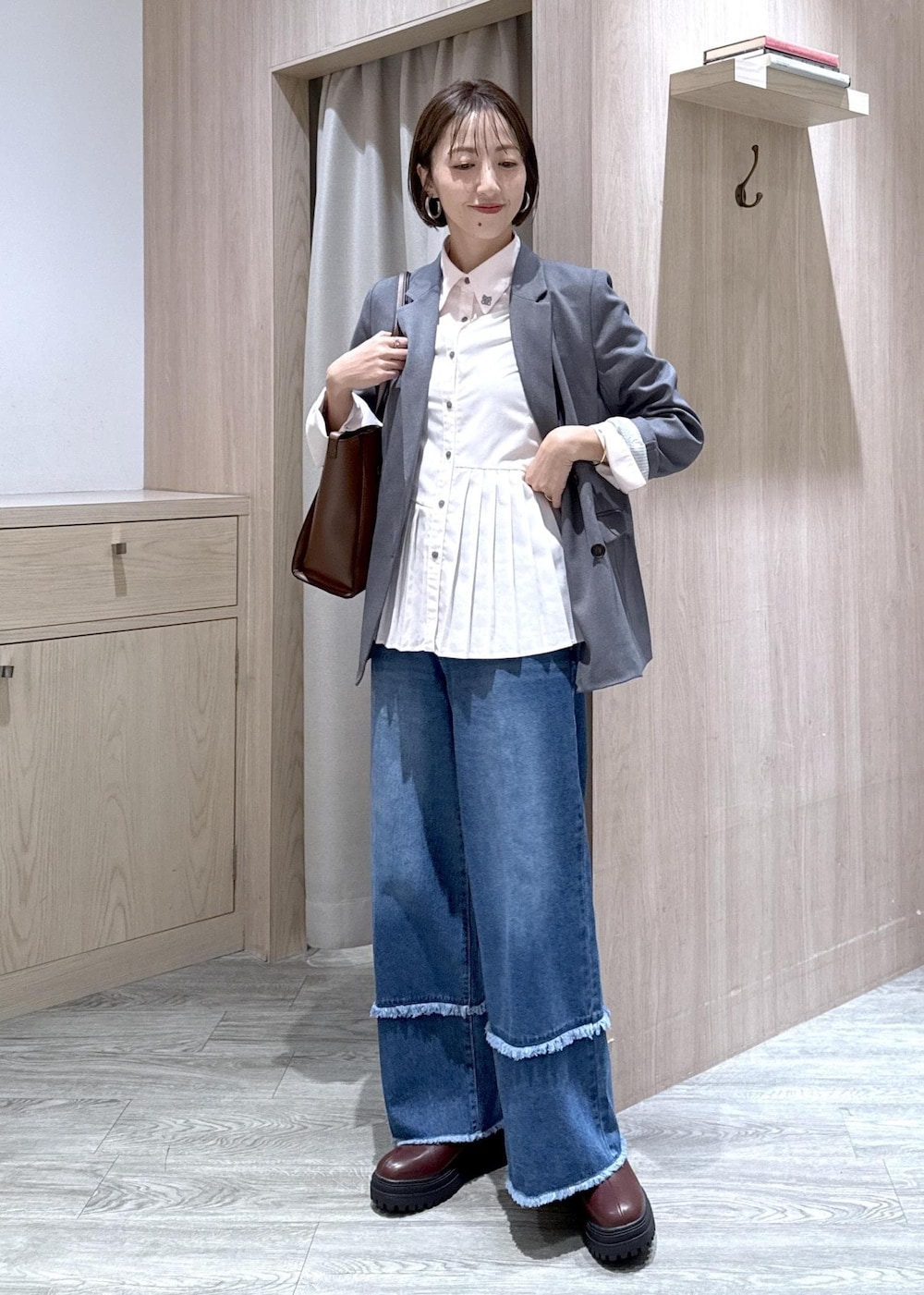 ブラウン系のブーツ、ピンク系のシャツ/ブラウス、ブルー系のデニムパンツを着用したレディースの秋コーディネートの10枚目の写真