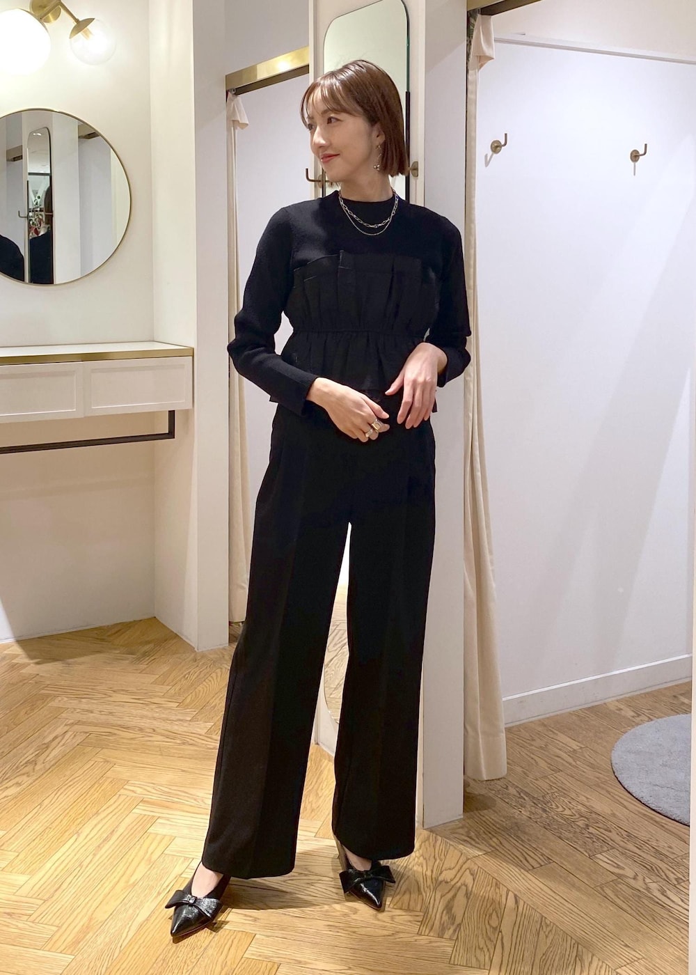 ブラック系のパンプス、ブラック系のニット/セーター、ブラック系のスラックスを着用したレディースの冬コーディネートの9枚目の写真