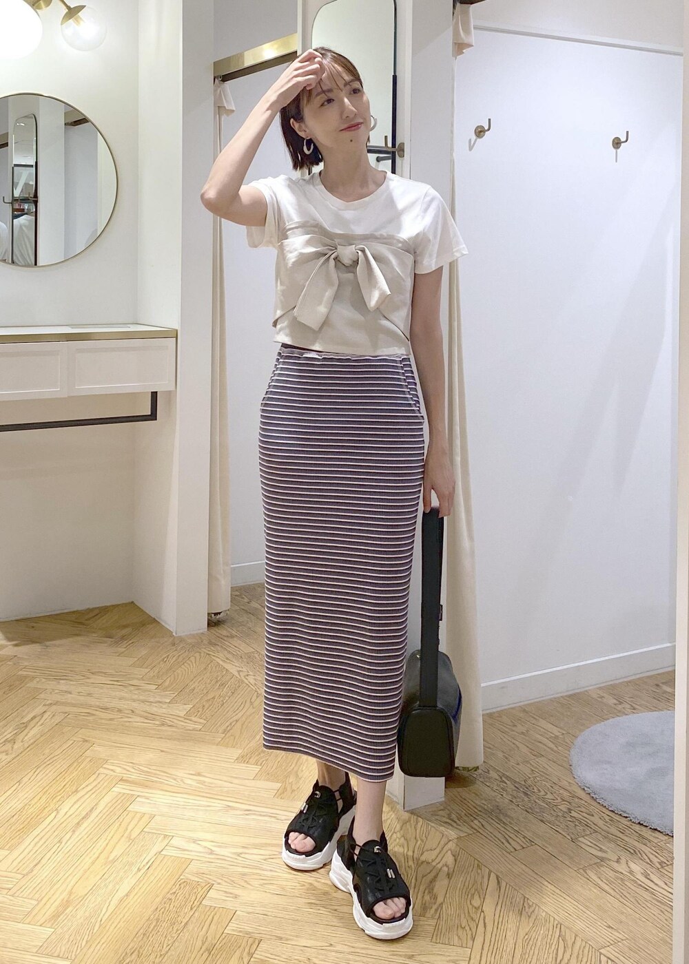 ブラック系のショルダーバッグ、ブラック系のサンダル、ブラック系のキャミソールを着用したレディースの夏コーディネートの4枚目の写真