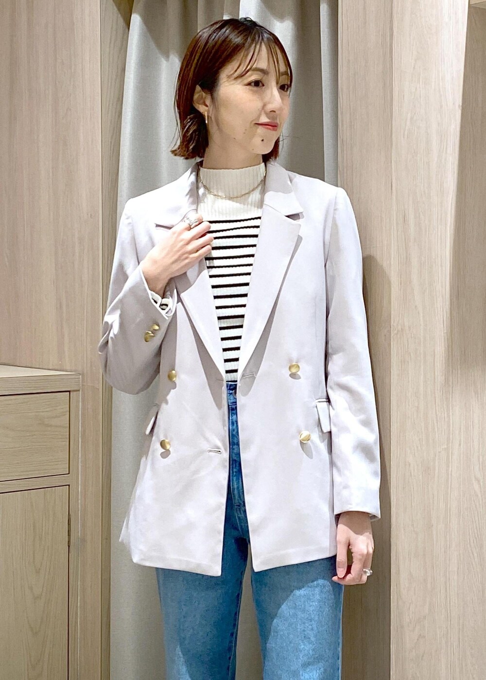 ブラック系のハンドバッグ、ホワイト系のニット/セーター、ベージュ系のテーラードジャケットを着用したレディースの冬コーディネートの8枚目の写真