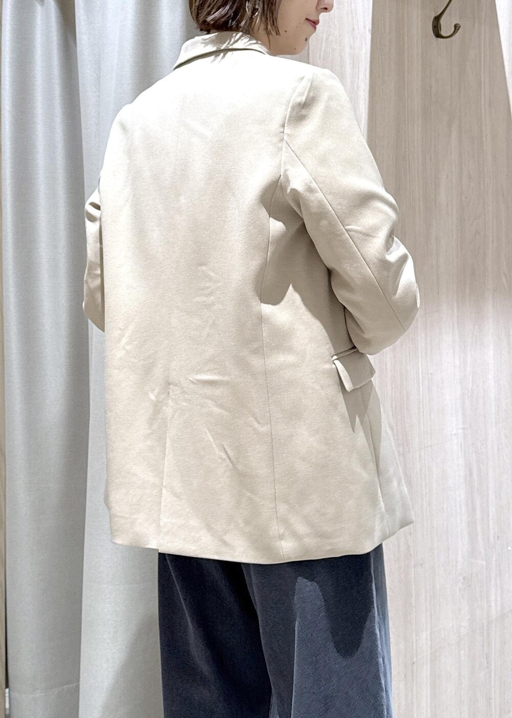 ブラック系のショルダーバッグ、ベージュ系のテーラードジャケット、ブラック系のブーツを着用したレディースの秋コーディネートの7枚目の写真