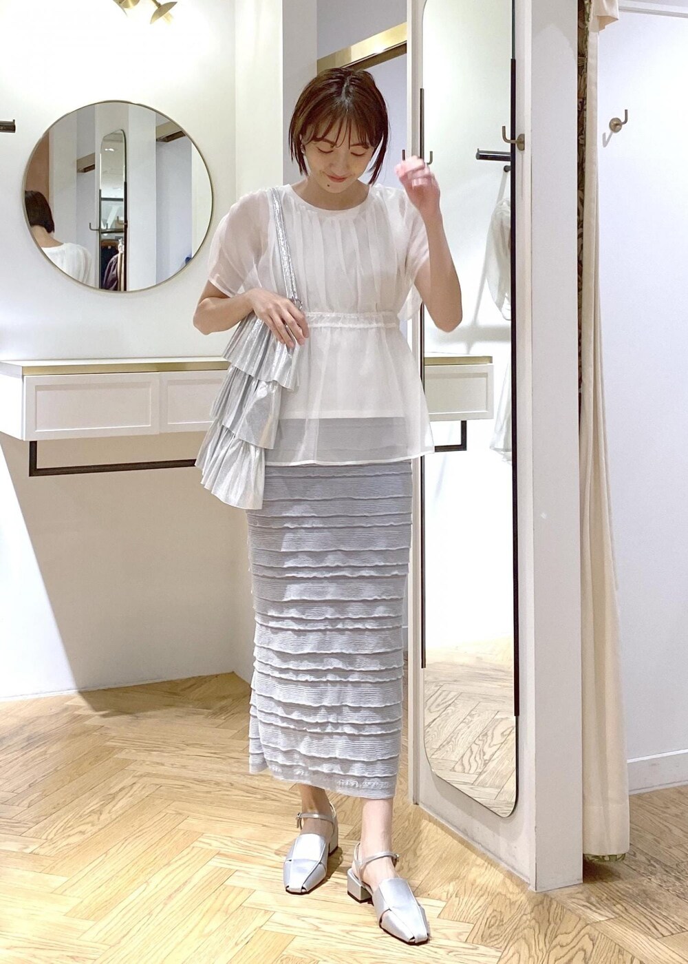 シルバー系のサンダル、シルバー系のトートバッグ、ホワイト系のTシャツ/カットソーを着用したレディースの夏コーディネートの5枚目の写真