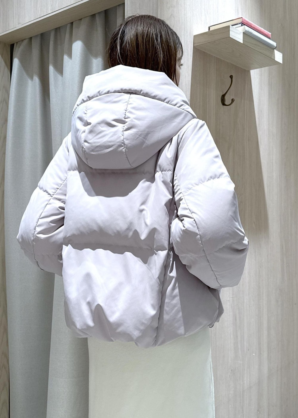 ブラック系のハンドバッグ、ピンク系のダウンジャケット/コート、ホワイト系のワンピースを着用したレディースの冬コーディネートの8枚目の写真