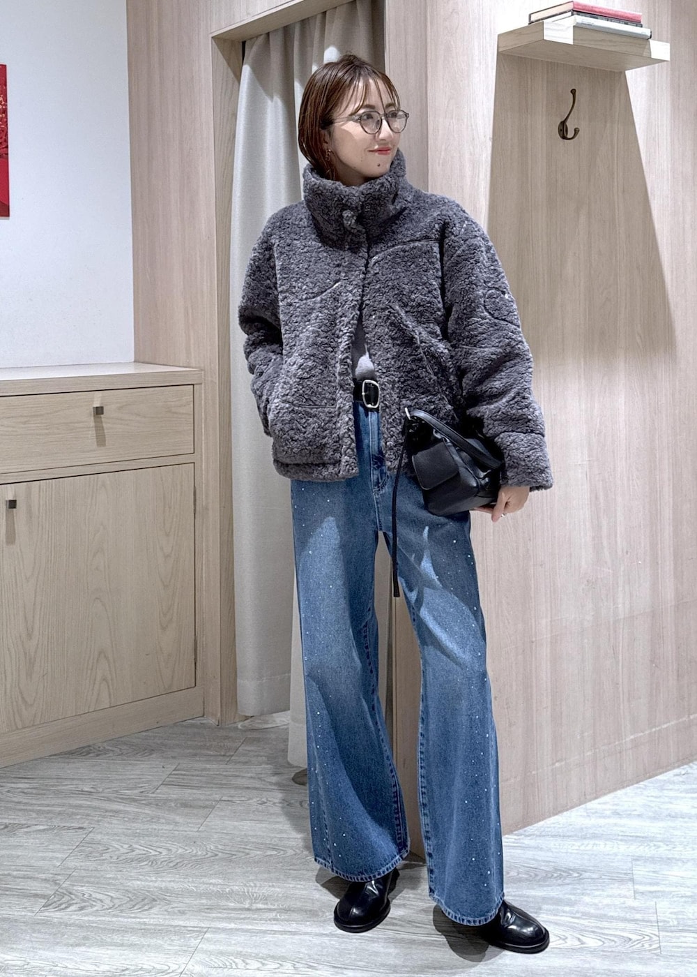 グレー系のブルゾン、グレー系のニット/セーター、ブルー系のデニムパンツを着用したレディースの冬コーディネートの8枚目の写真