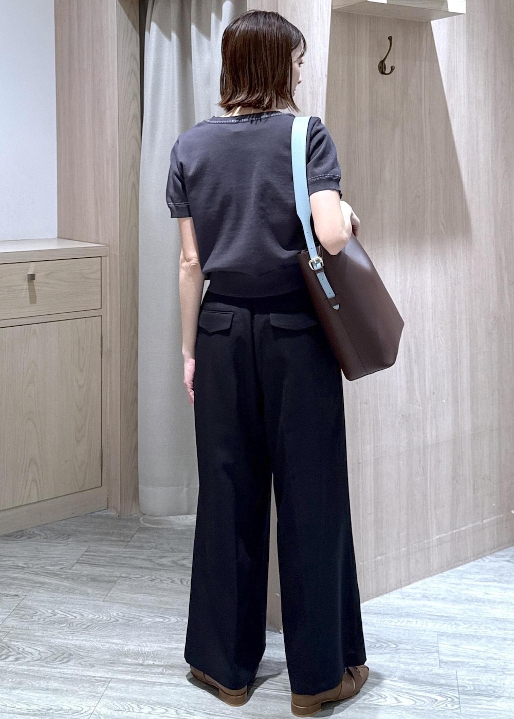 ブラウン系のトートバッグ、ブラウン系のパンプス、ブラック系のその他パンツを着用したレディースの春コーディネートの2枚目の写真