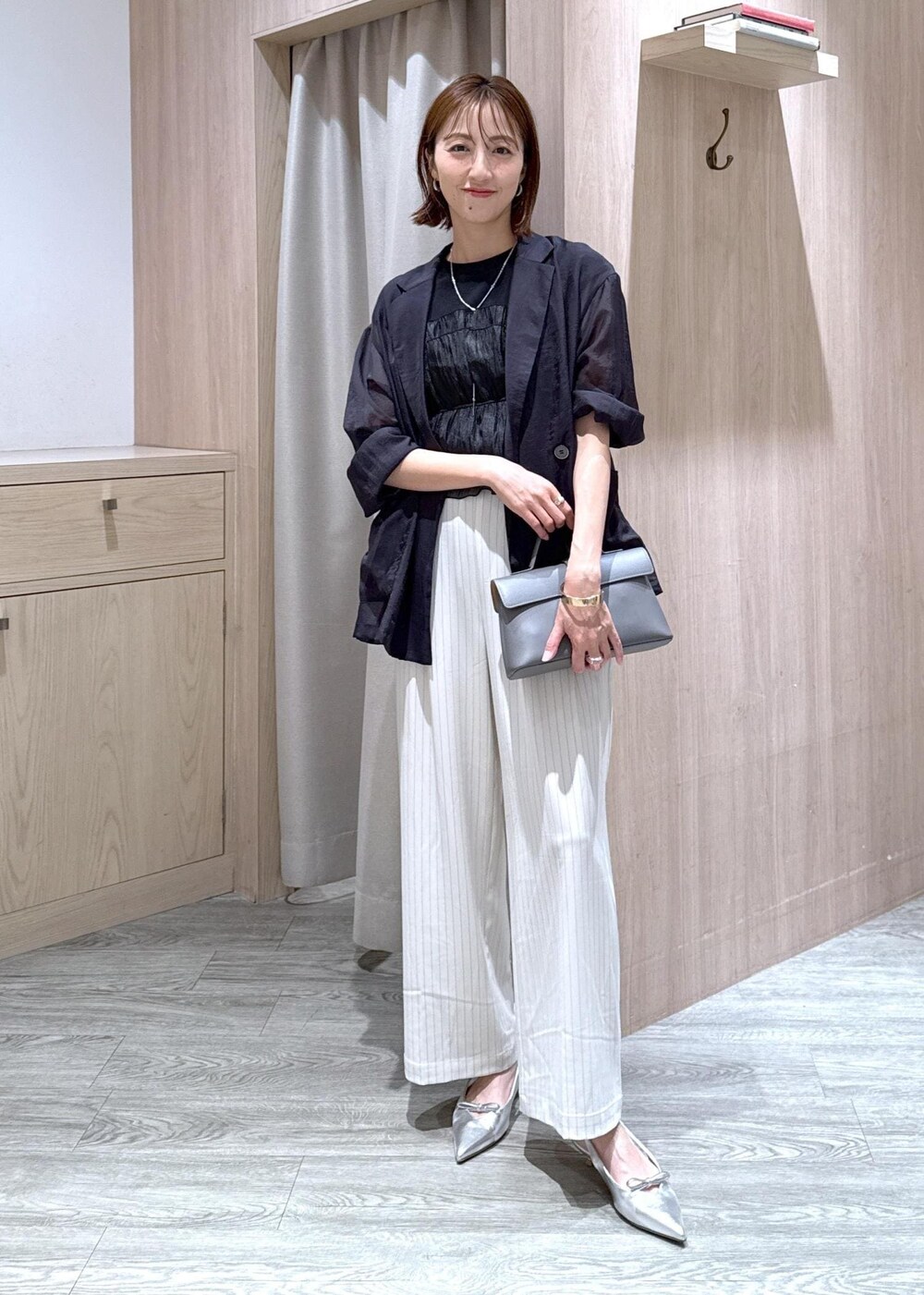 グレー系のショルダーバッグ、シルバー系のパンプス、ブラック系のTシャツ/カットソーを着用したレディースの夏コーディネートの4枚目の写真